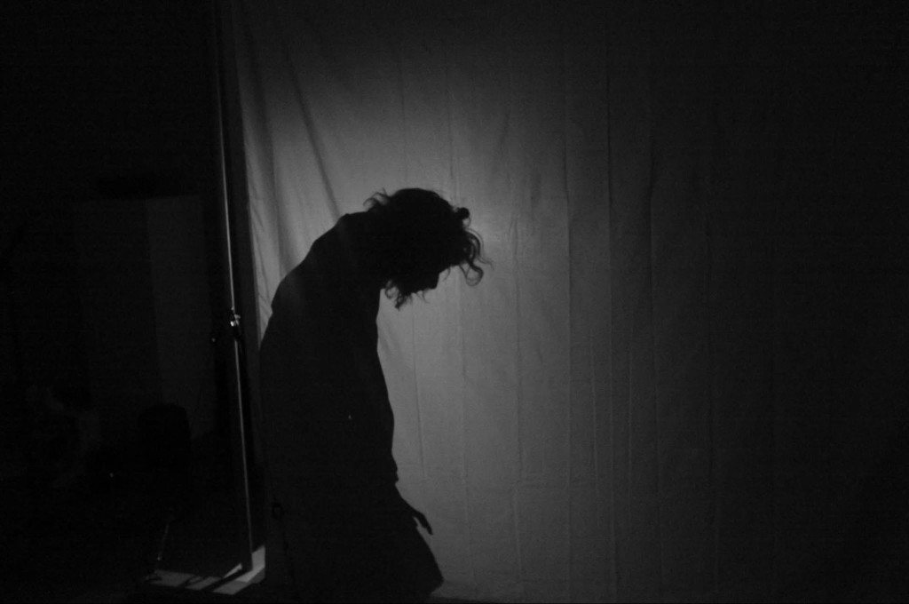 A dancer on the floor, arms extended — the body as presence
