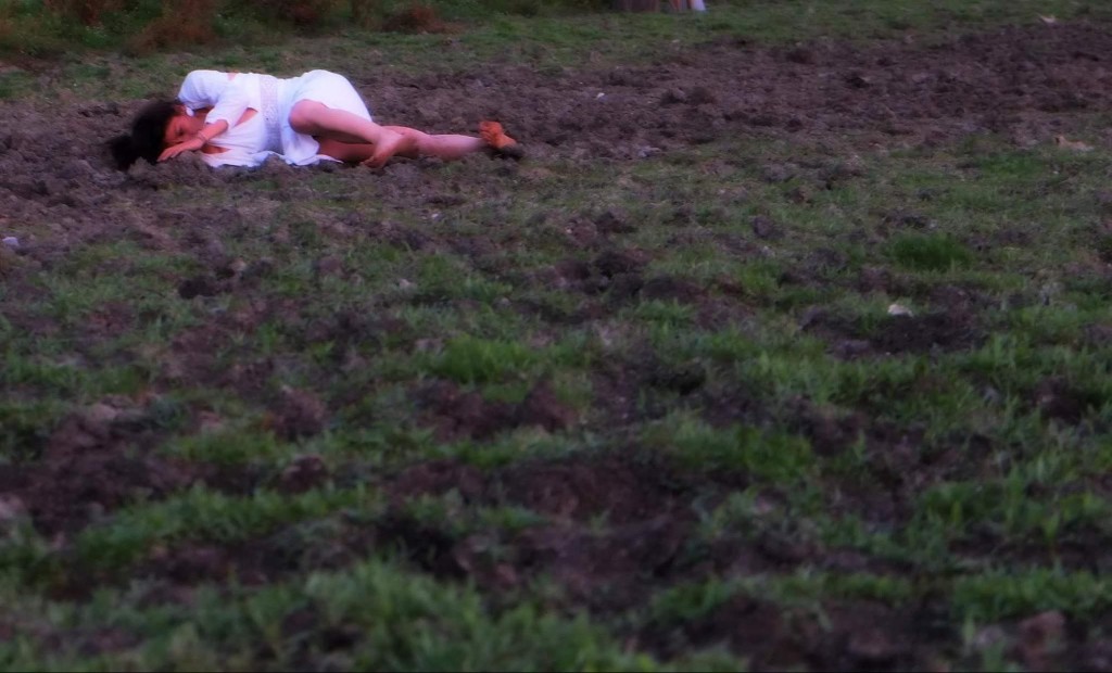 A dancer lying in a field of earth — Body Weather Farm, Japan