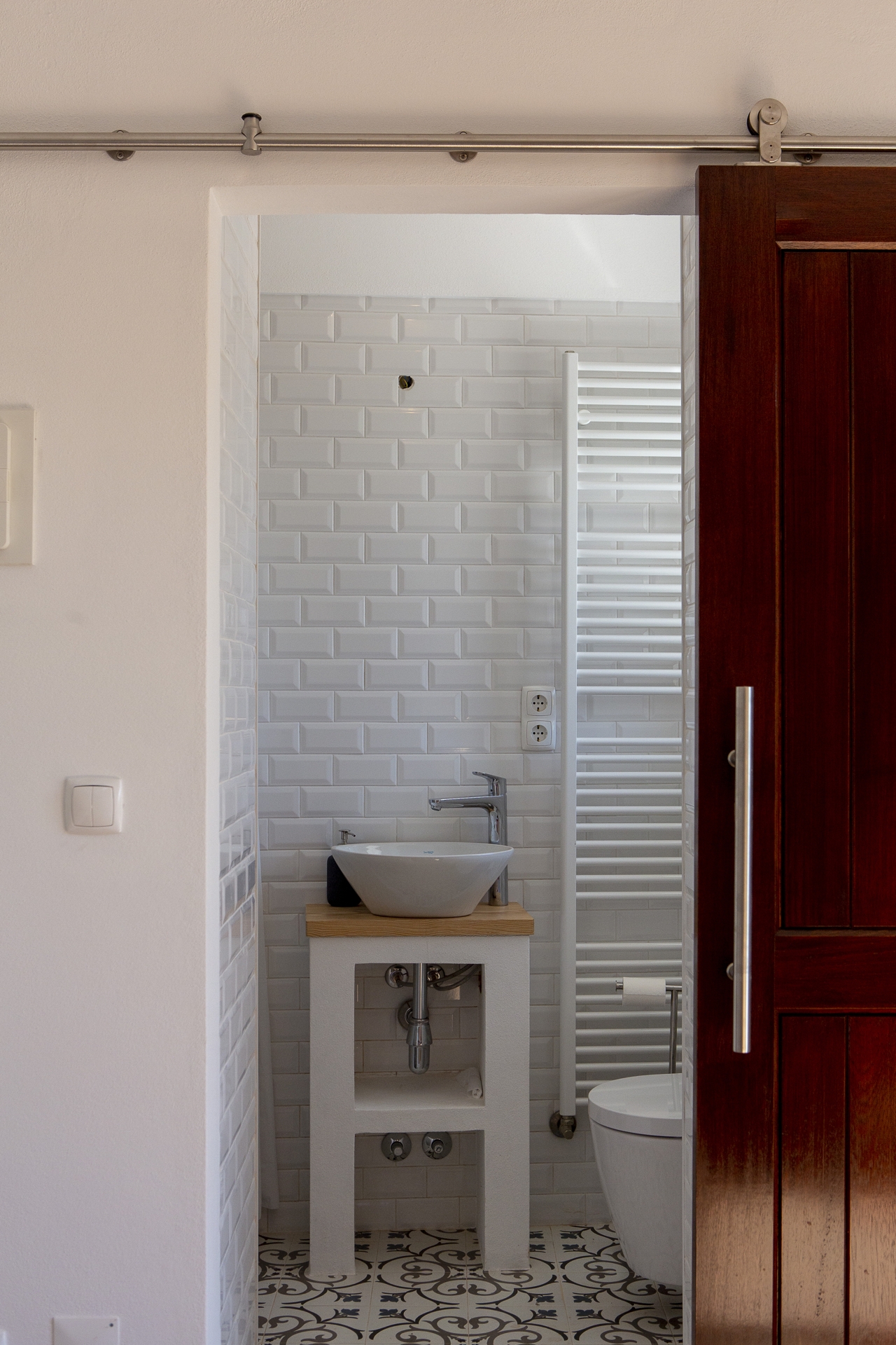Ensuite bathroom with white subway tiles and patterned floor at Bodhi Bhavan